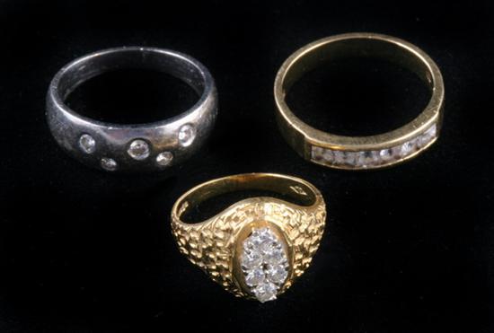 Appraisal: THREE K GOLD AND DIAMOND RINGS One yellow gold band