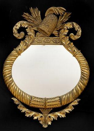 Appraisal: CLASSICAL CARVED GILTWOOD MIRROR The oval plate within leaf-bound diagonal