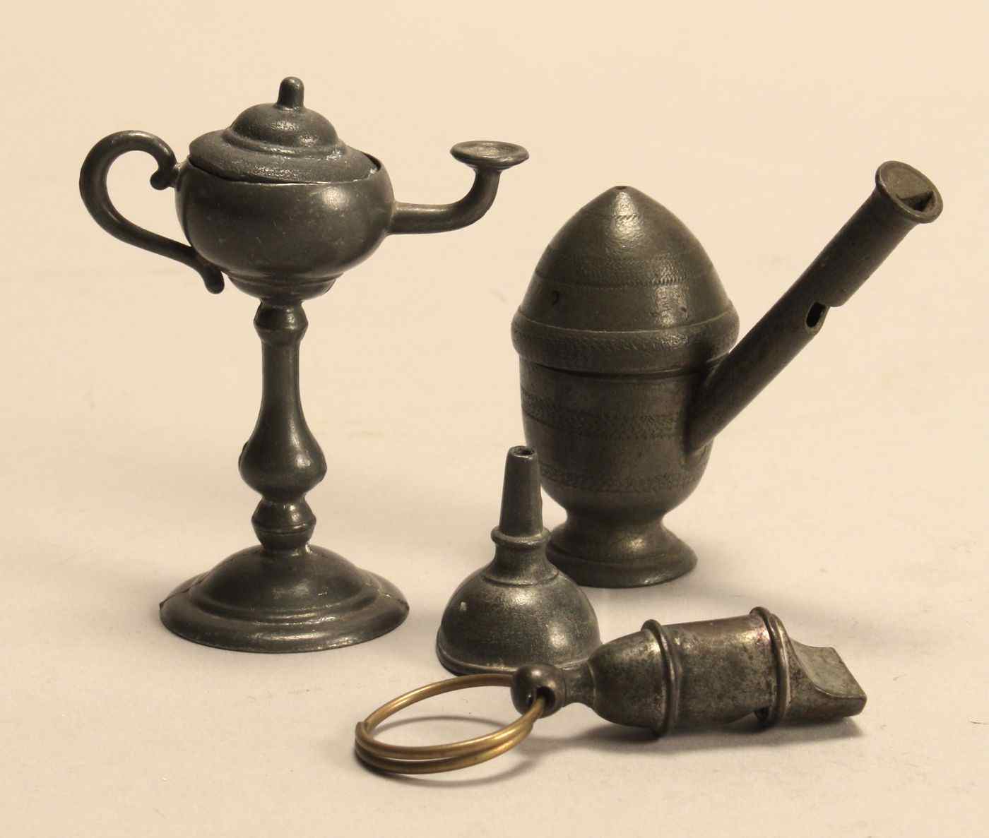 Appraisal: FOUR AMERICAN PEWTER MINIATURES th CenturyTwo whistles one lamp and