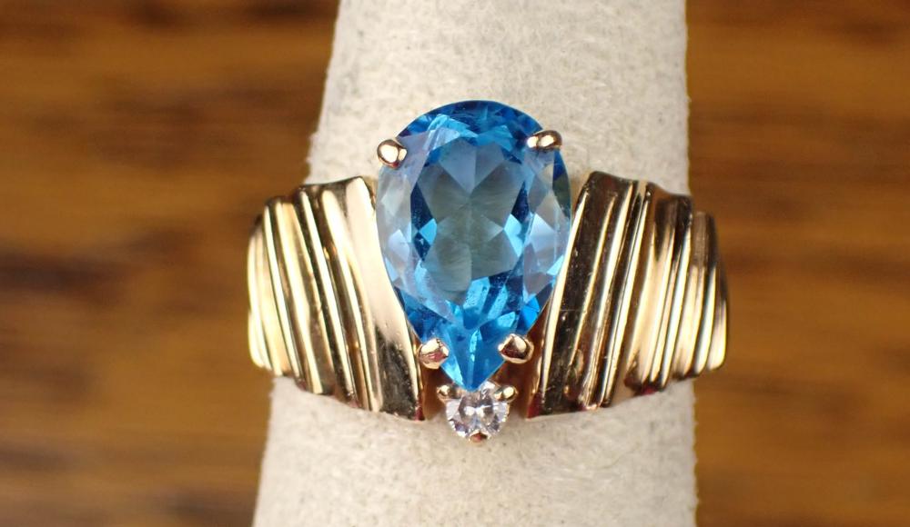 Appraisal: BLUE TOPAZ AND DIAMOND RING K yellow gold single pear-cut