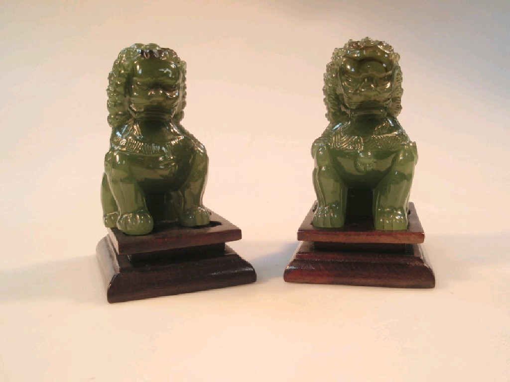 Appraisal: A pair of Chinese jade seated Bhuddistic lions on raised