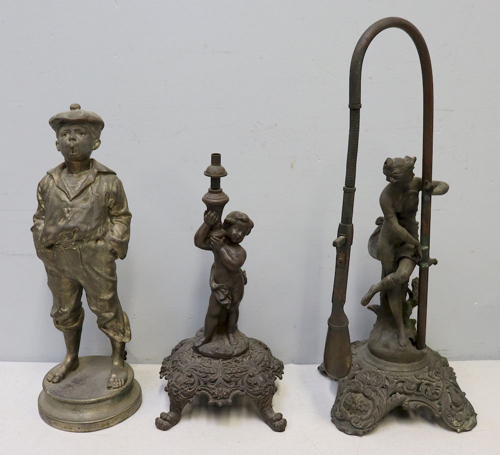 Appraisal: Patinated Metal Figural Cigar Lighters To include a Cherub holding