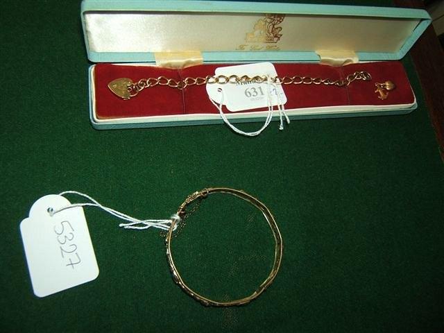 Appraisal: A gold curb link bracelet with padlock clasp and three