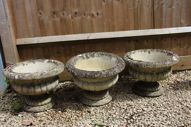 Appraisal: A SET OF THREE COMPOSITE URNS of shallow campana form