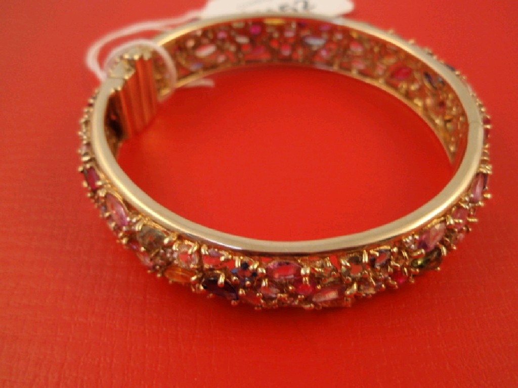 Appraisal: A heavy hinged bangle set overall with multi coloured gems