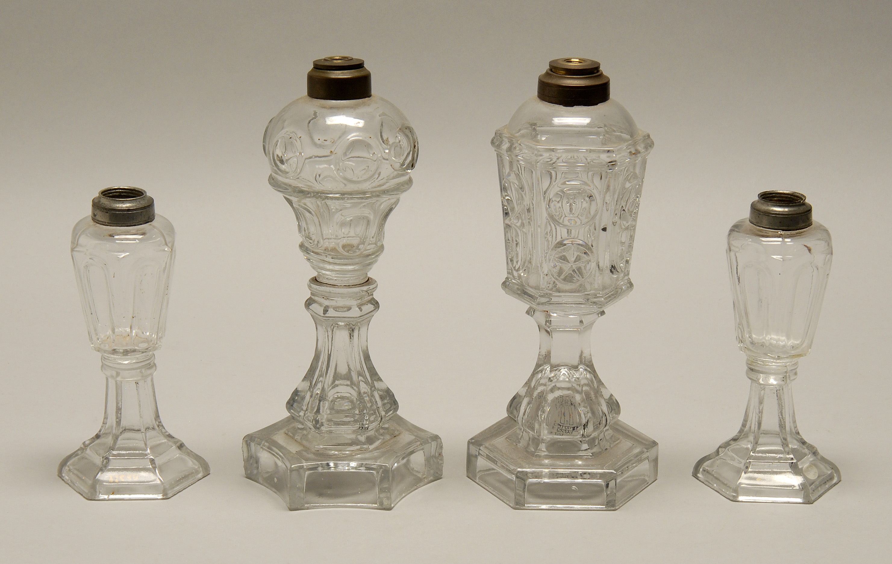 Appraisal: FOUR SANDWICH PRESSED COLORLESS GLASS WHALE OIL LAMPS th CenturyPair