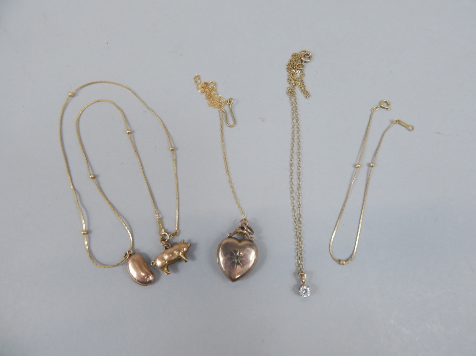 Appraisal: A pig charm attached to a slender link necklace heart