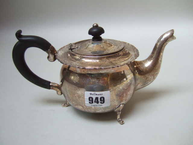 Appraisal: A silver teapot with a shaped rim raised on three