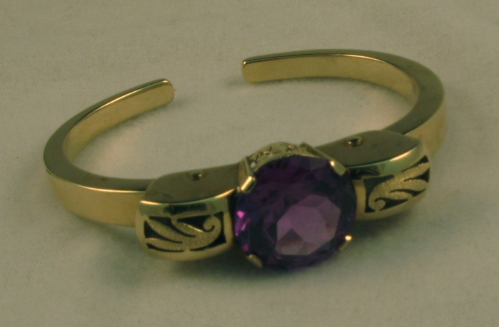 Appraisal: SYNTHETIC ALEXANDRITE AND FOURTEEN KARAT GOLD BANGLE set with a