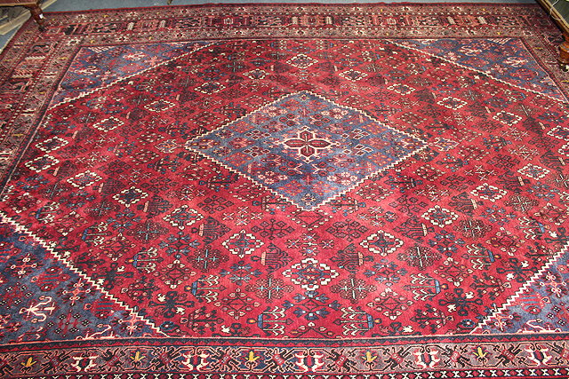 Appraisal: PERSIAN MEIMEH WINE GROUND RUG central diamond motif pleating floral