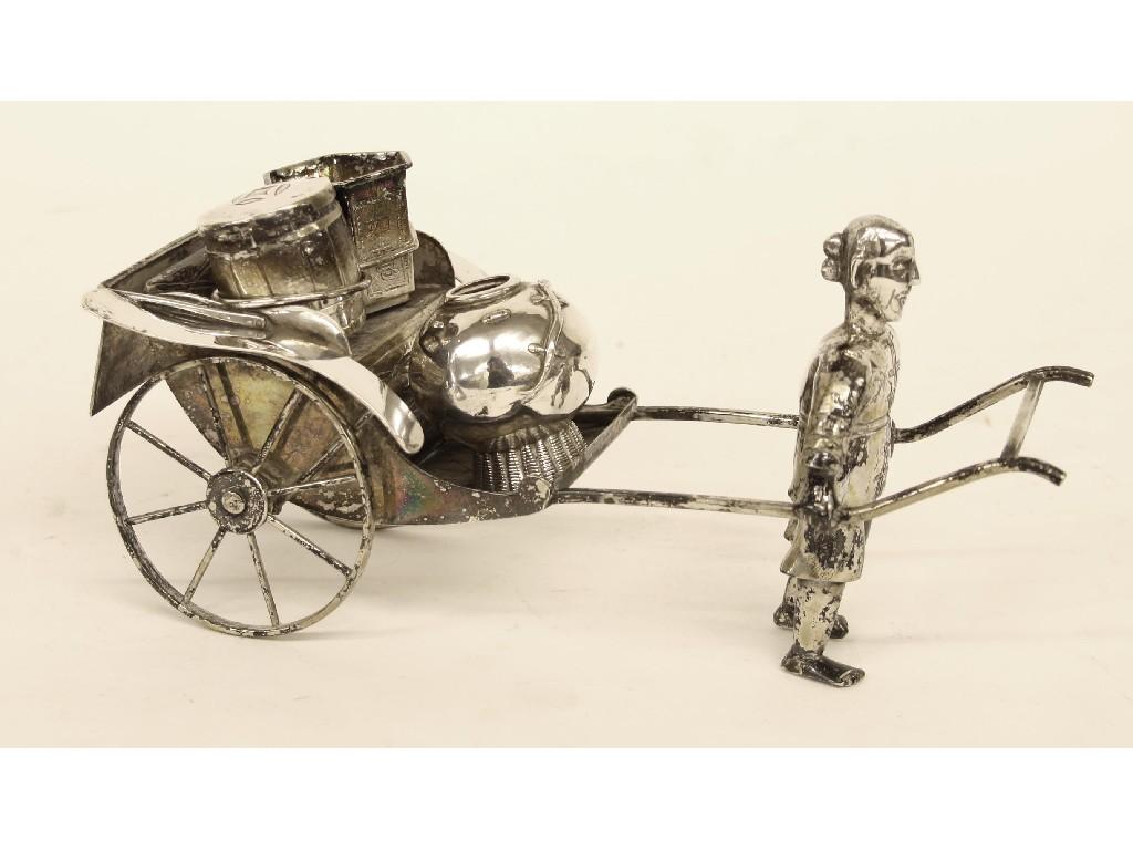 Appraisal: Oriental white metal ornament modelled as a street vendor pulling