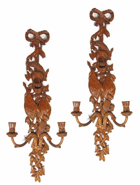 Appraisal: A pair of Continental carved walnut two light wall sconces