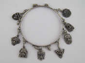 Appraisal: A white metal test silver charm bracelet being a bangle