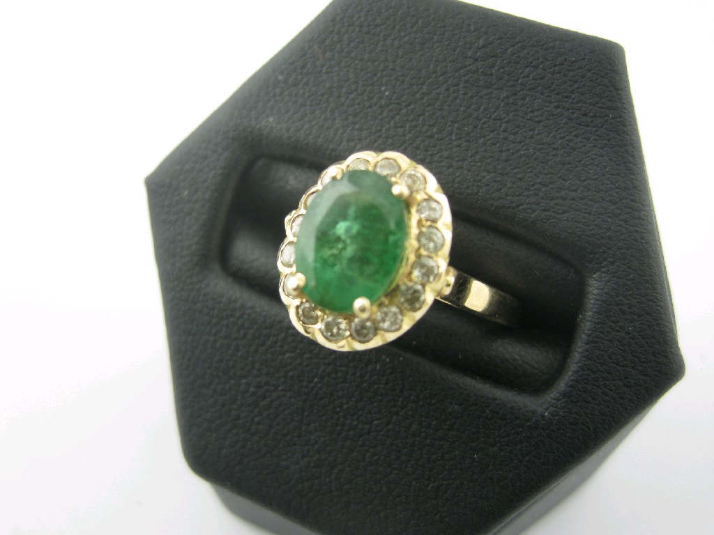 Appraisal: An Emerald and Diamond Cluster Ring the central oval-cut emerald