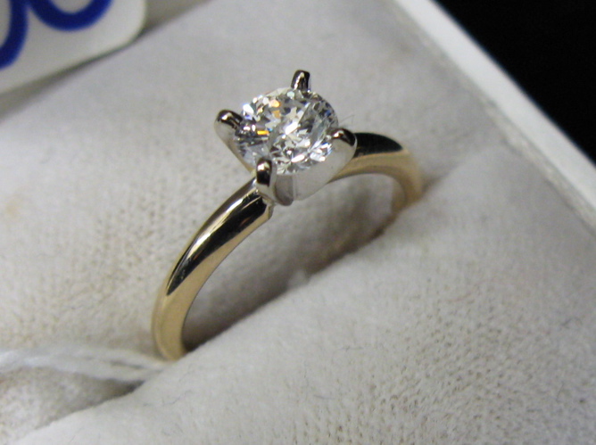 Appraisal: DIAMOND AND FOURTEEN KARAT YELLOW AND WHITE GOLD SOLITAIRE RING