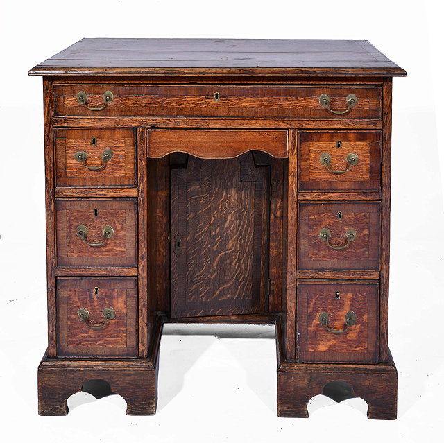 Appraisal: AN ANTIQUE OAK KNEEHOLE DESK with mahogany cross banded decoration