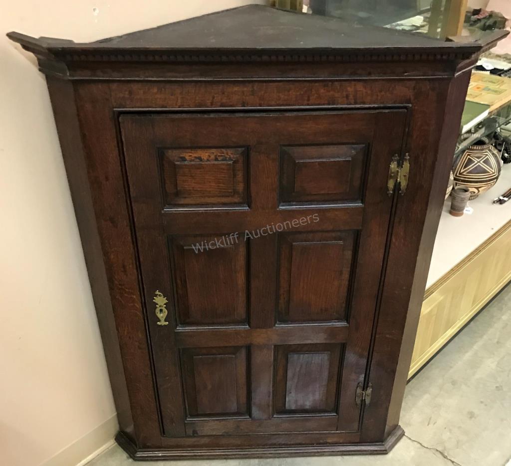 Appraisal: An antique oak wall-mount corner cupboard three interior shelves raised