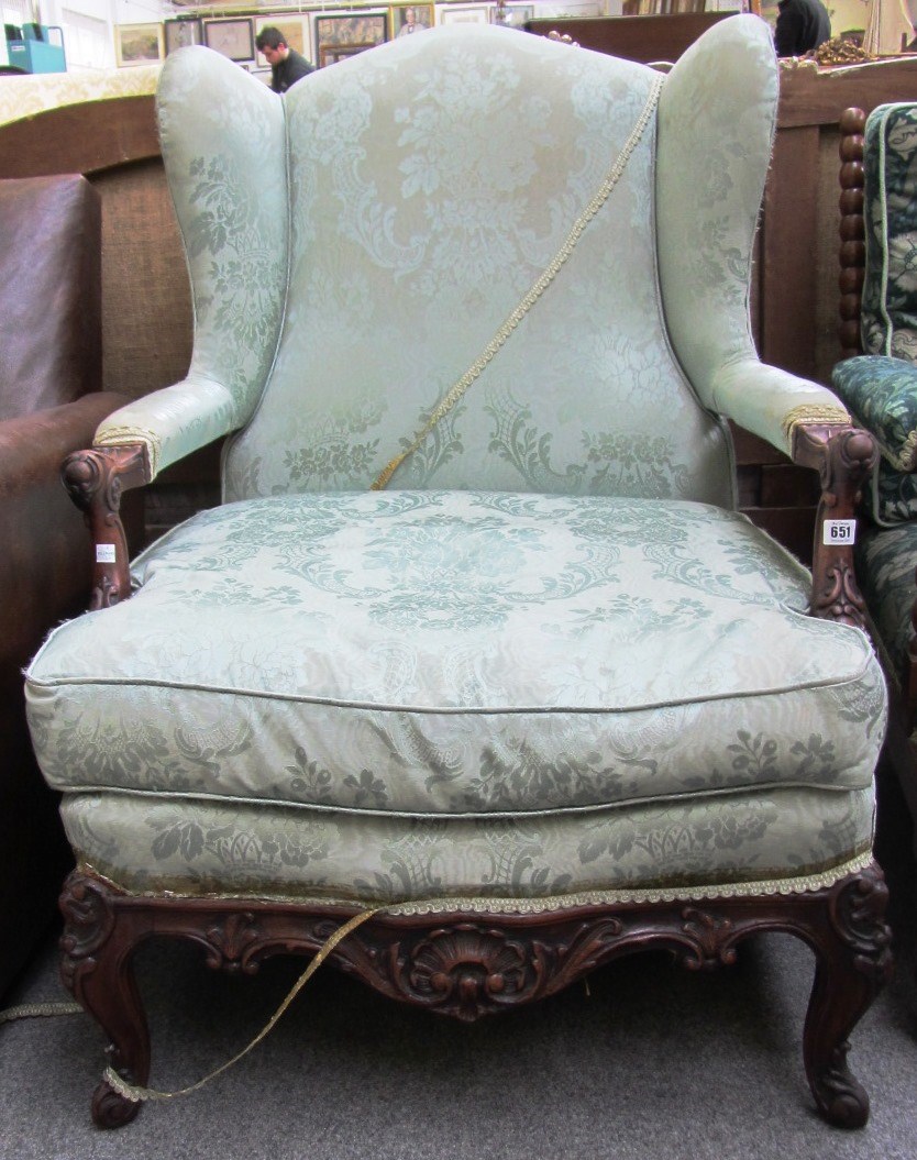 Appraisal: An early th century mahogany framed wingback armchair with carved