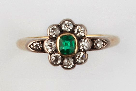 Appraisal: AN EMERALD AND DIAMOND CLUSTER RING the cushion-shaped emerald collet