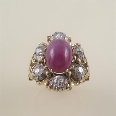 Appraisal: A ruby and diamond cluster ring the oval shaped cabochon