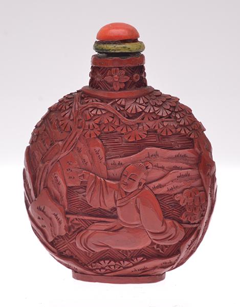 Appraisal: A CARVED CINNABAR SNUFF BOTTLE WITH CORAL STOPPER