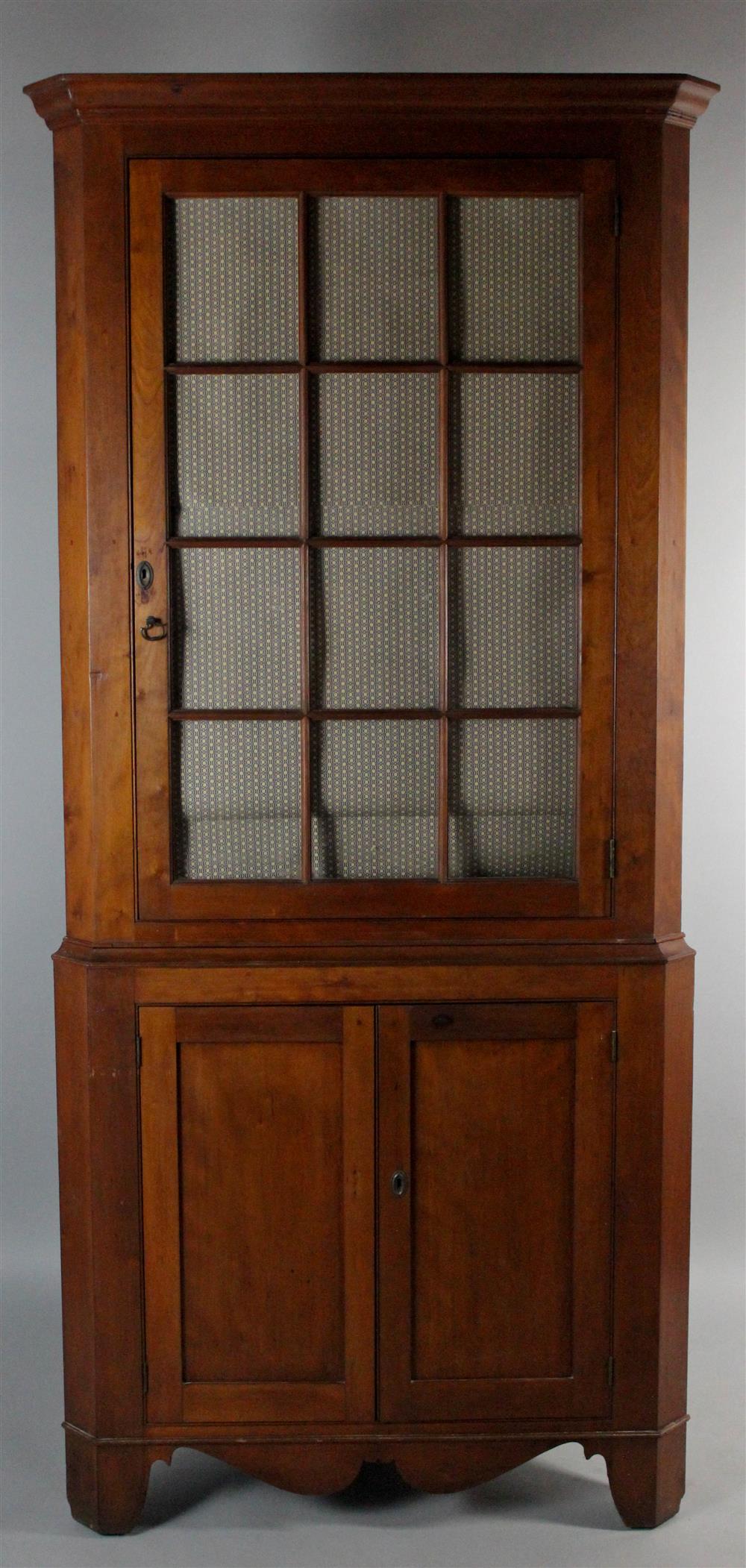 Appraisal: AMERICAN CHERRYWOOD TWO PART CORNER CUPBOARD having an outset molded