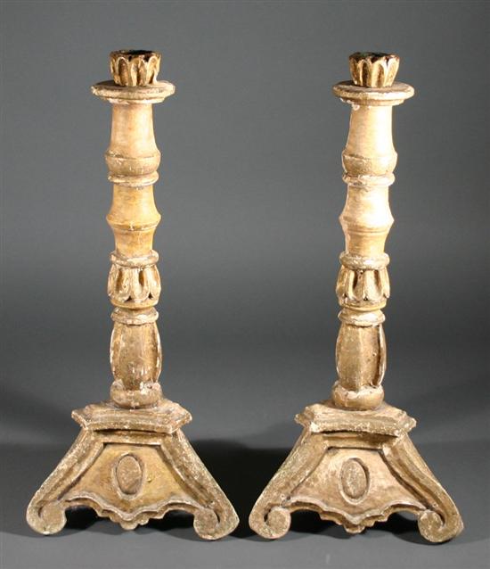 Appraisal: Pair of gilded wood carved candlesticks Each raised on a