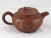 Appraisal: A Yixing style Chinese red teapot of melon form incised