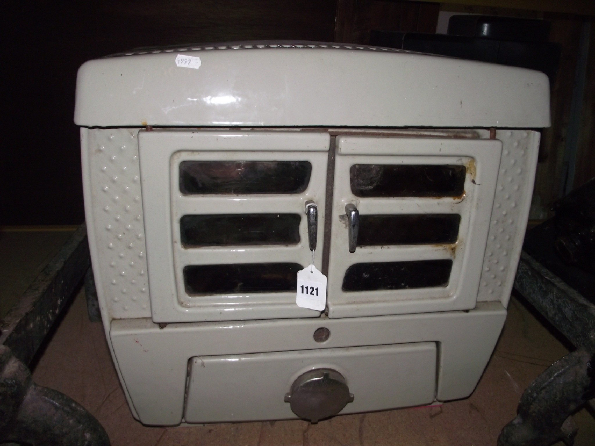 Appraisal: A vintage cast iron and cream enamelled stove enclosed by