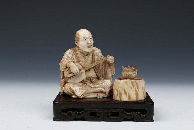 Appraisal: A JAPANESE CARVED IVORY TWO PIECE FIGURE of a seated