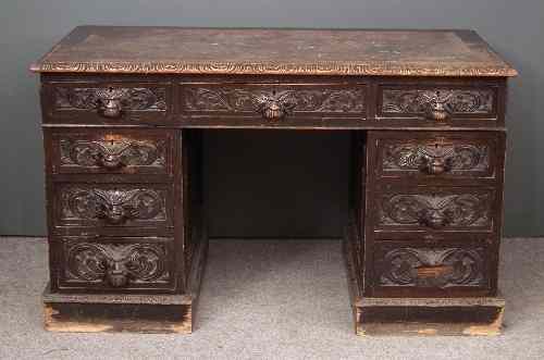 Appraisal: A Victorian ''Black Oak'' kneehole desk carved throughout with face