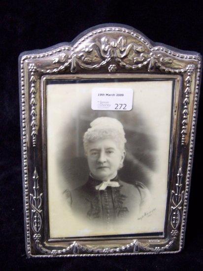 Appraisal: A photograph frame embossed bell drops ribbons and swags to