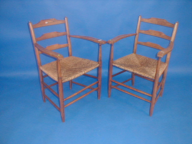 Appraisal: A pair of elm ladder back carver chairs in the