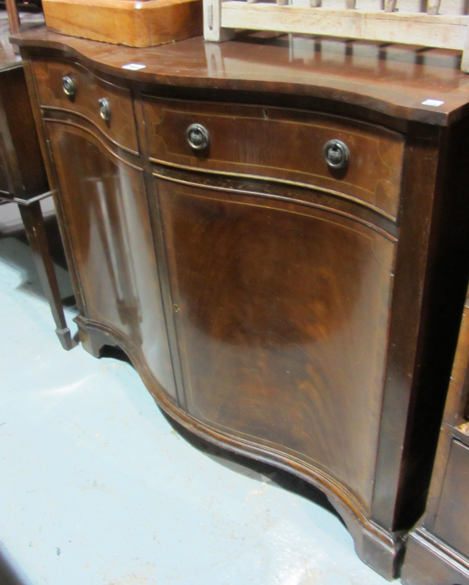 Appraisal: A th century mahogany serpentine side cabinet