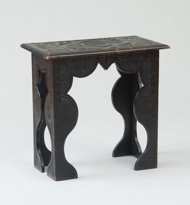 Appraisal: SPANISH COLONIAL CARVED EBONIZED SIDE TABLE The overhanging top carved