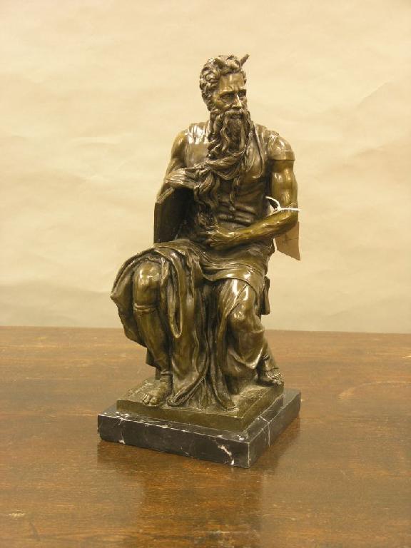 Appraisal: A patinated bronze figure of a seated Moses bearded character