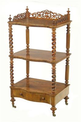 Appraisal: A Victorian walnut serpentine front whatnot with a pierced three