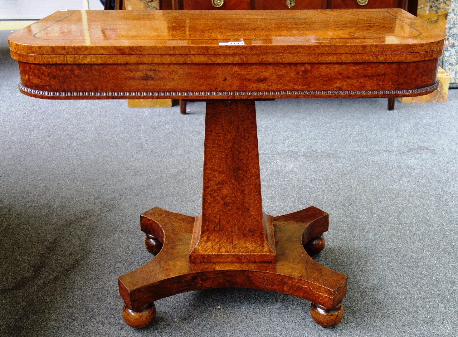 Appraisal: A George IV figured walnut card table on flared square