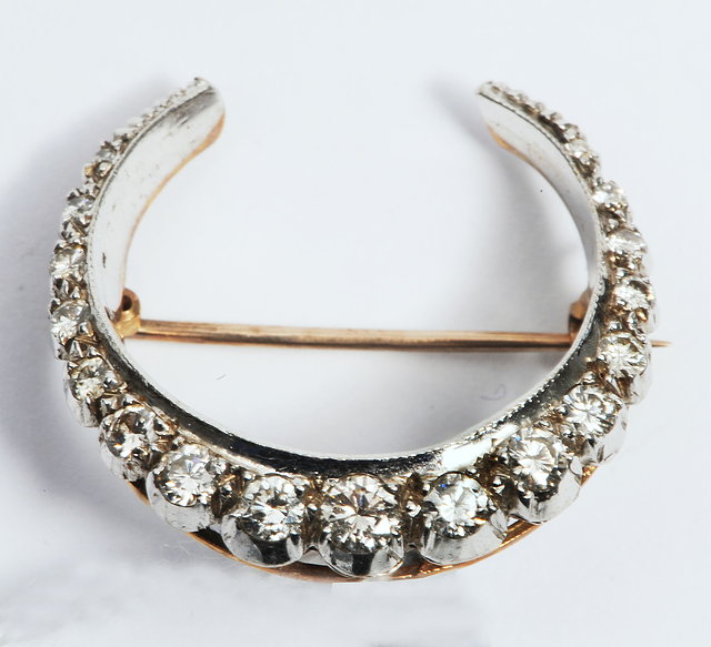 Appraisal: A CRESCENT SHAPED BROOCH with graduated multi diamond decoration