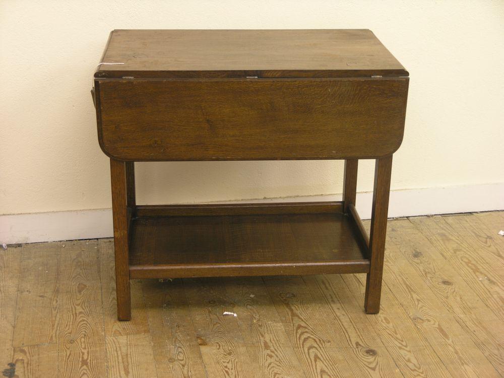 Appraisal: A solid dark oak drop leaf table with undertier ft