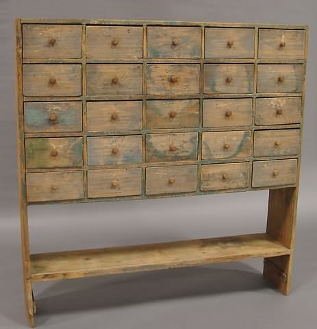 Appraisal: Twenty-five small drawers with wood pulls stretcher shelf traces of