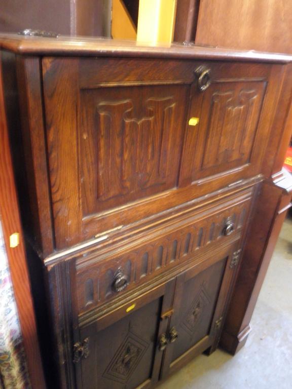 Appraisal: An oak cocktail cabinet with linen fold carved panels