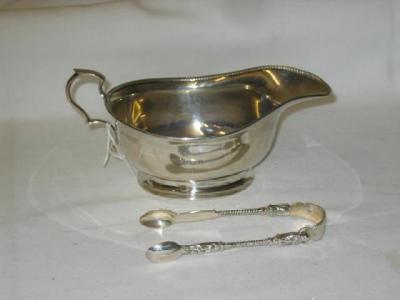 Appraisal: A SAUCE BOAT with beaded rim scroll handle and moulded