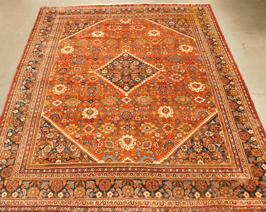 Appraisal: HERIZ NAVY AND ORANGE GEOMETRIC FLORAL CARPET RUG Middle East