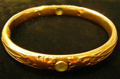 Appraisal: karat yellow gold peridot and diamond bangle braceletFloral engraved bangle