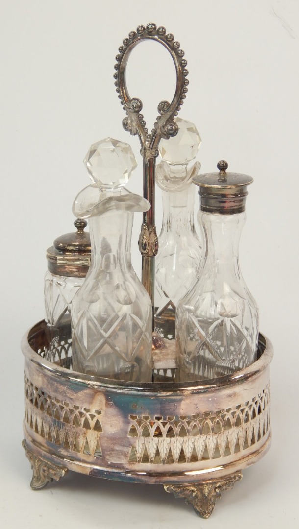 Appraisal: A silver plated four bottle table cruet with foliate gallery