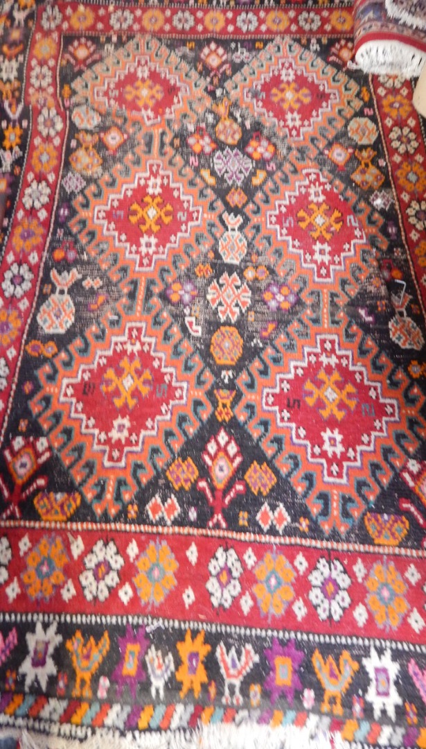 Appraisal: A Caucasian black ground rug decorated with floral and geometric