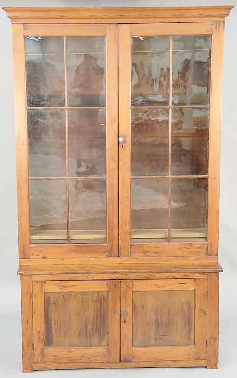 Appraisal: Primitive pine cupboard having two glazed doors on base with