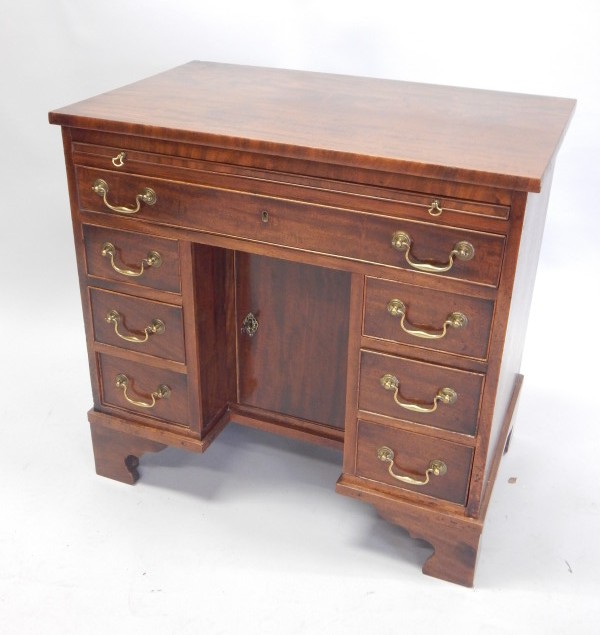 Appraisal: A mahogany kneehole desk the rectangular top above a brushing