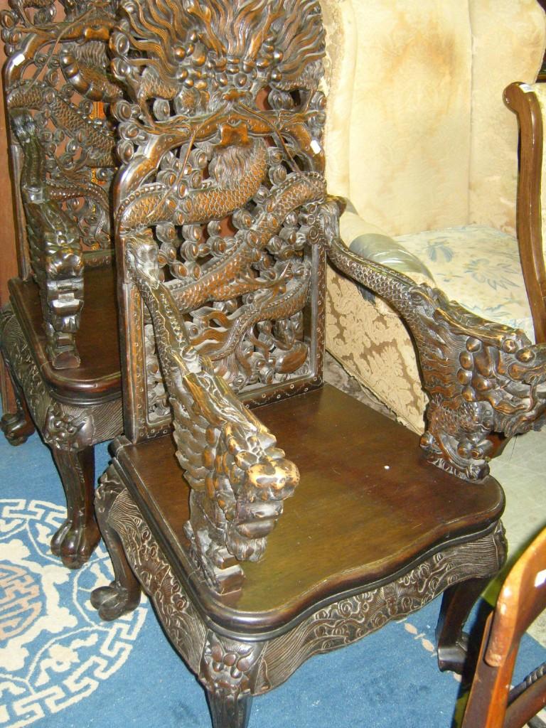 Appraisal: A pair of Chinese hardwood elbow chairs with profusely carved